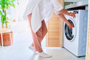 Woman Using Modern Washing Machine Laundry Home